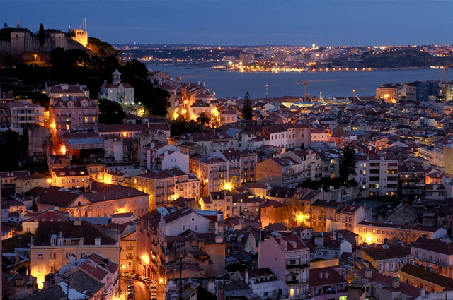 view of lisbon castle over the river at night